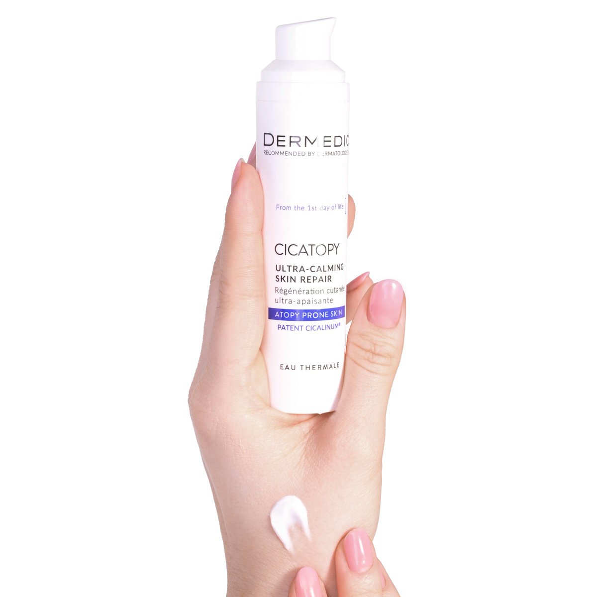 A hand pumps Dermedic Cicatopy Ultra-Calming Skin Repair Cream onto the back of another hand, showing the product and a small amount of cream on the skin.